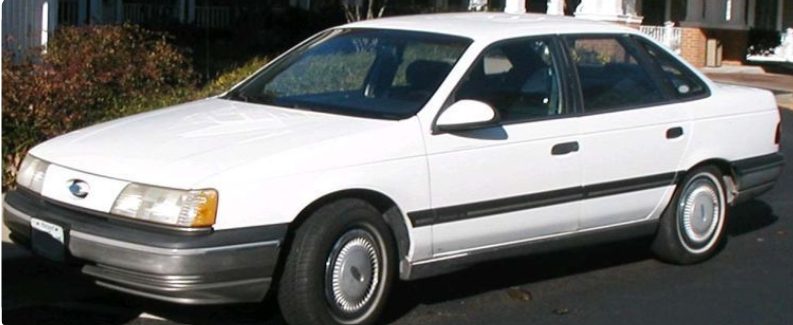 A 1998 white ford taurus sedan
